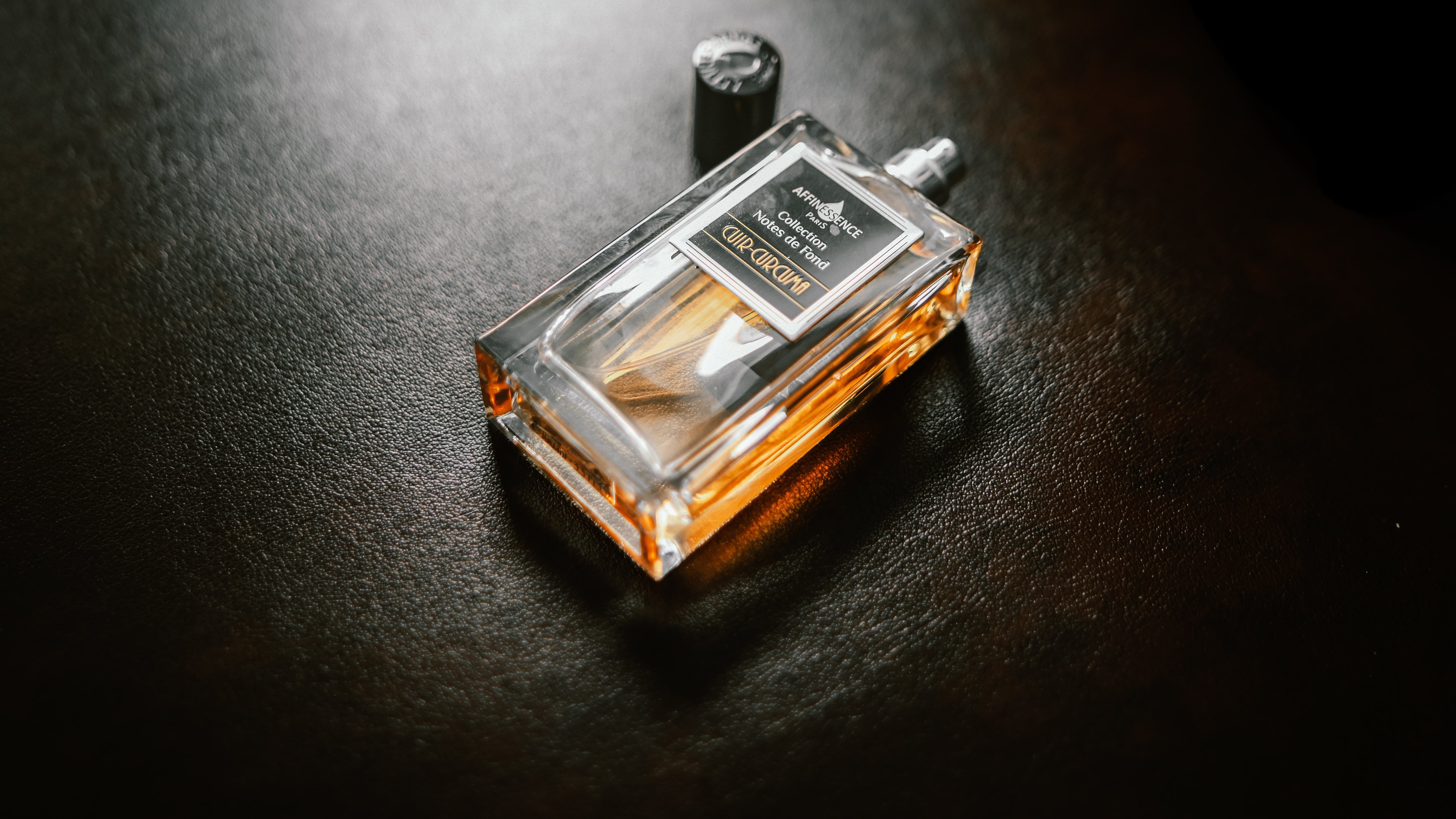 Frasco de perfume com tampa ao lado